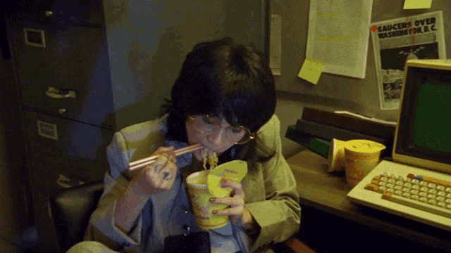 a woman eating noodles with chopsticks in front of a bulletin board that says sauces over washington dc