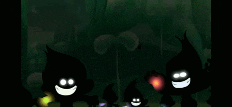 a group of trolls are standing next to each other in the dark .