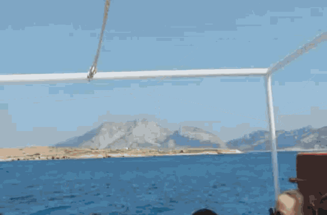 a man stands on the back of a boat looking at the ocean
