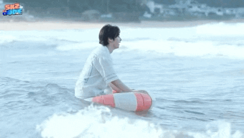 a man is sitting on a life preserver in the water .