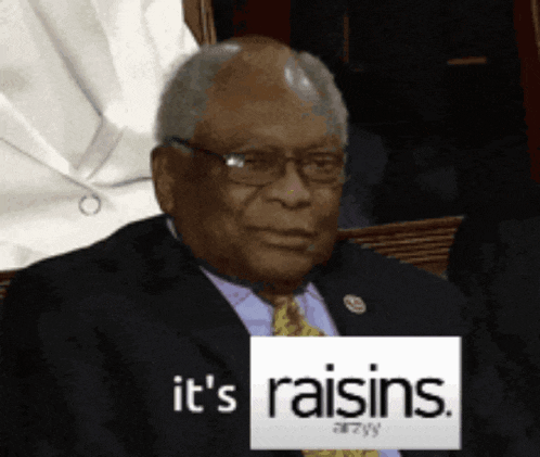 a man in a suit and tie holding a sign that says it 's raisins