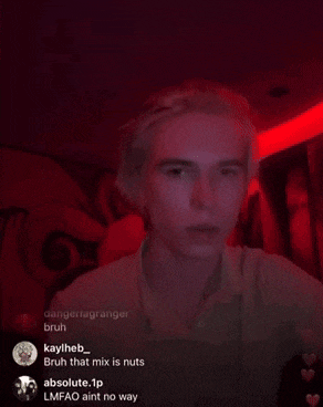 a man with his eyes closed is sitting in a dark room with a red light behind him