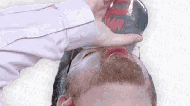 a man with a beard is drinking from a glass that says coca cola on it