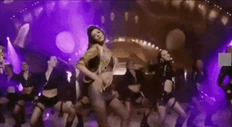 a group of women are dancing on a stage in a club .
