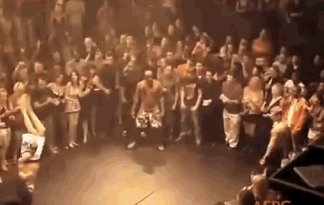 a man is dancing in front of a crowd with the word afro on the bottom right corner