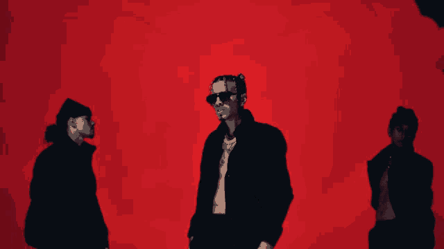 three men are standing in front of a red background with smoke coming out of it