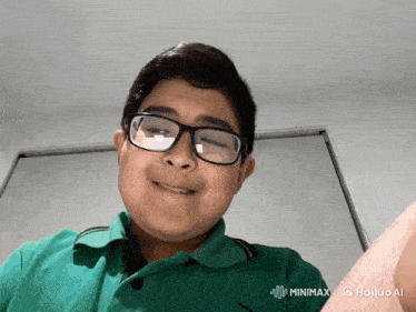 a young boy wearing glasses and a green polo shirt is smiling