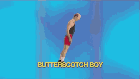 a man in red shorts is jumping in the air with the words butterscotch boy behind him .