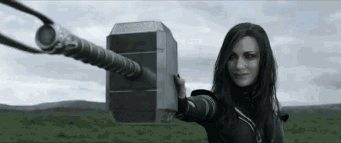 a woman is holding a large hammer in her hand .