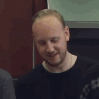 a bald man with a beard is smiling and saying yeah
