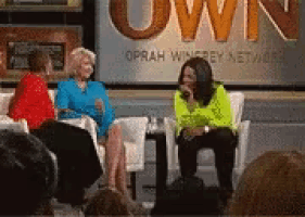 three women are sitting on a stage in front of a sign that says oprah winfrey network