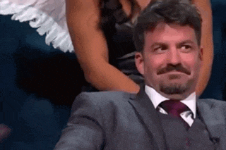 a man in a suit and tie is sitting next to a woman in a dress .