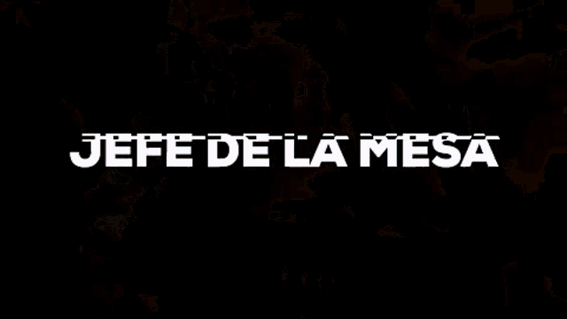 a group of men are sitting around a table with the words jefe de la mesa written on the bottom .
