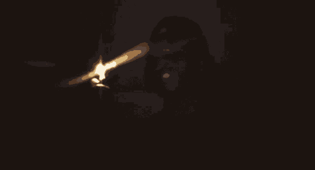 a person lighting a candle in the dark