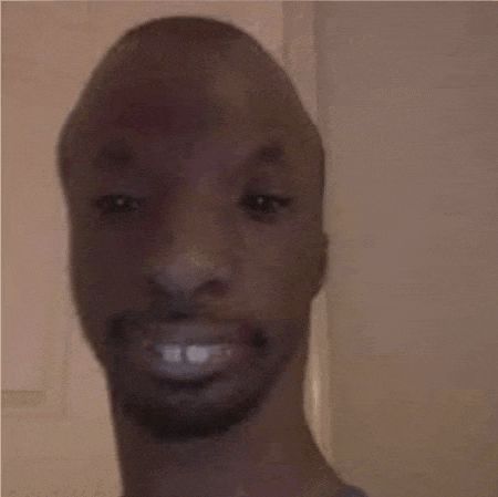 a close up of a man 's face with a beard and a smile .