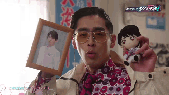 a man holding a stuffed animal and a framed picture of another man
