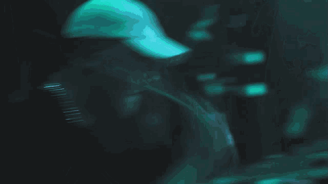 a blurry picture of a person playing drums with a green light behind them