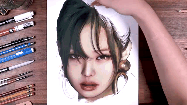 a person is drawing a woman 's face with pencils and pens on a wooden table