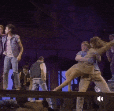 a group of people are dancing in a dark room with a speaker icon in the corner