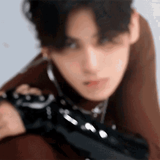 a blurry picture of a young man wearing a turtleneck sweater and black gloves .