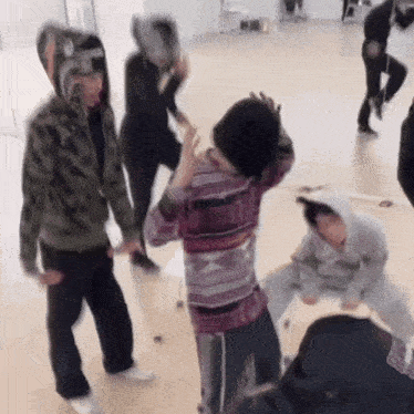 a group of people are dancing in a room with a man wearing a hoodie that says a bathing ape on it
