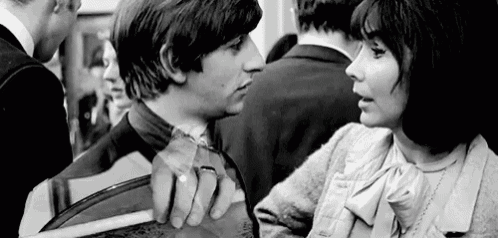 a man and a woman are standing next to each other in a crowded room .