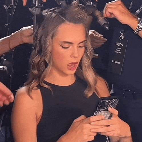 a woman getting her hair done with a lanyard that says loreal