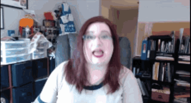 a woman is sitting in a chair in front of a bookshelf with a blue bag that says ' blue ' on it
