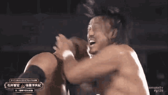 two men are fighting in a ring and one of them has a sign that says # g129