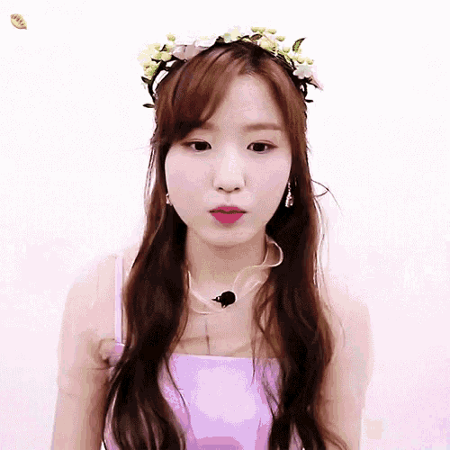 a woman wearing a purple top and a flower crown