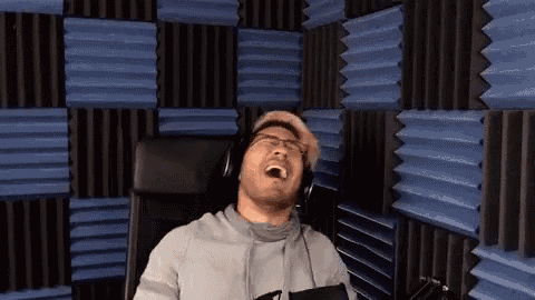 a man wearing headphones is sitting in a chair in front of a blue and black wall .
