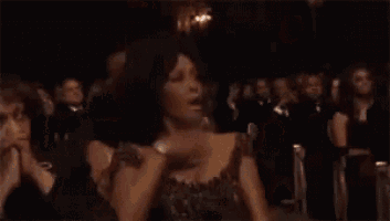 a woman is dancing in a dark room with candles .