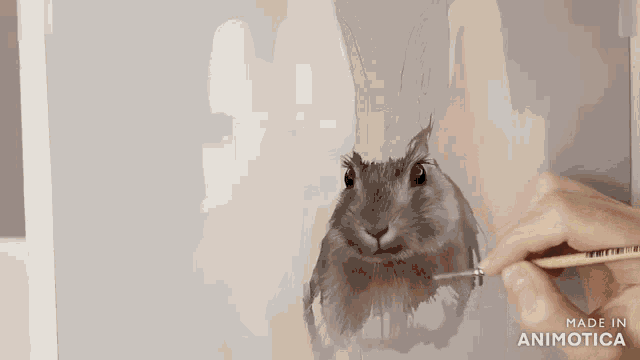 a person is painting a rabbit on a canvas with the words made in animotica below it