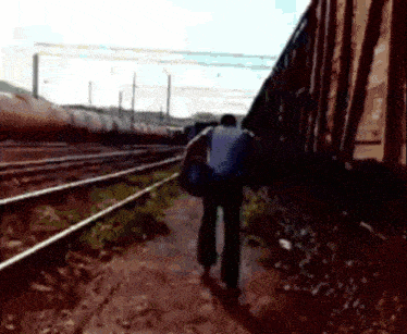 a person is walking along train tracks with a backpack