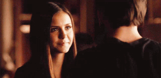 a man and a woman are looking at each other .