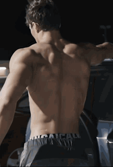 the back of a shirtless man with calvin klein underwear on