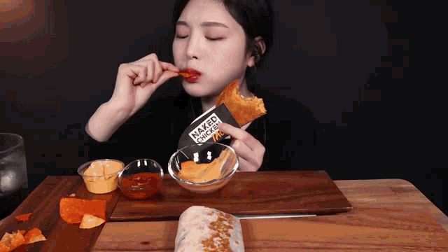 a woman is eating a naked chicken taco on a table