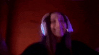 a woman wearing headphones is making a scary face with her hands .