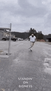 a man is standing on a skateboard in a parking lot while wearing a mask .