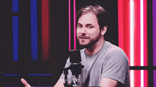 a man is sitting in front of a microphone and smiling .