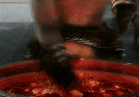 a person is standing in front of a fire with sparks flying around them