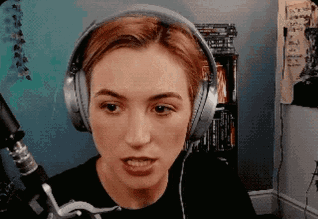 a woman wearing headphones looks at the camera