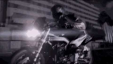 a man is riding a motorcycle on a city street at night .