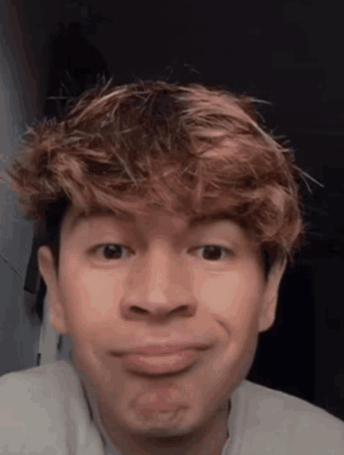 a young man with red hair is making a face