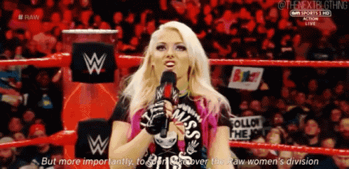 a woman in a wrestling ring is talking into a microphone while wearing a shirt that says miss