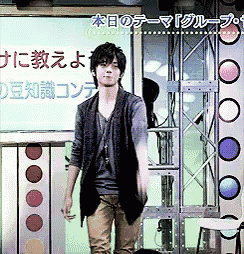 a man is standing in front of a sign that says ' a ' on it