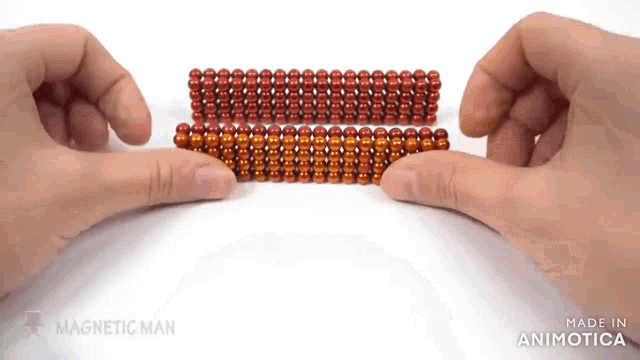 a person is holding a bunch of red beads in their hands ..