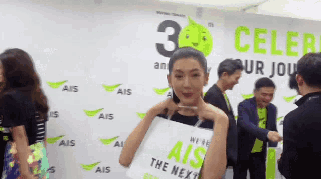 a woman holds a bag that says ais the next