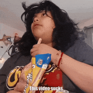 a woman is holding a bag of ice cream and says " this video sucks " on the bottom