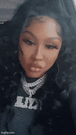 a close up of a woman 's face wearing a necklace and a black shirt .